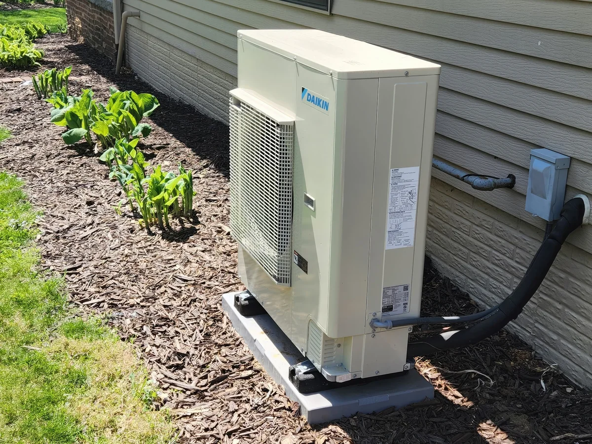 Dixon's installed Daikin outdoor cooling unit beside a residential home