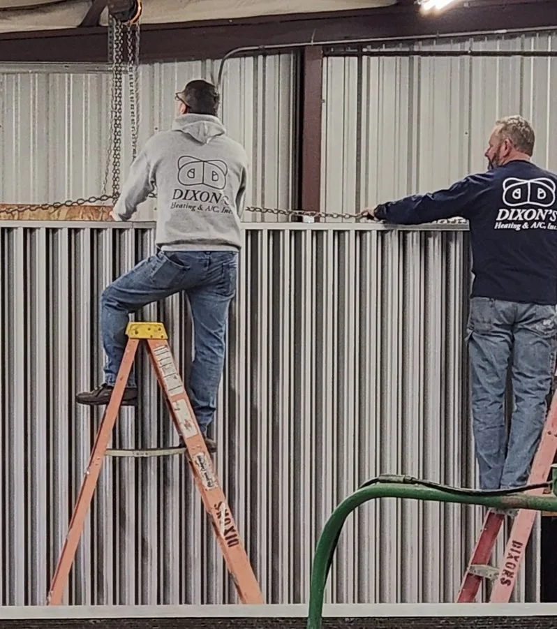 Dixon's technician on a ladder during a Springfield-area service call.