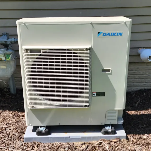 New Daikin Fit outdoor condenser set on a fresh pad