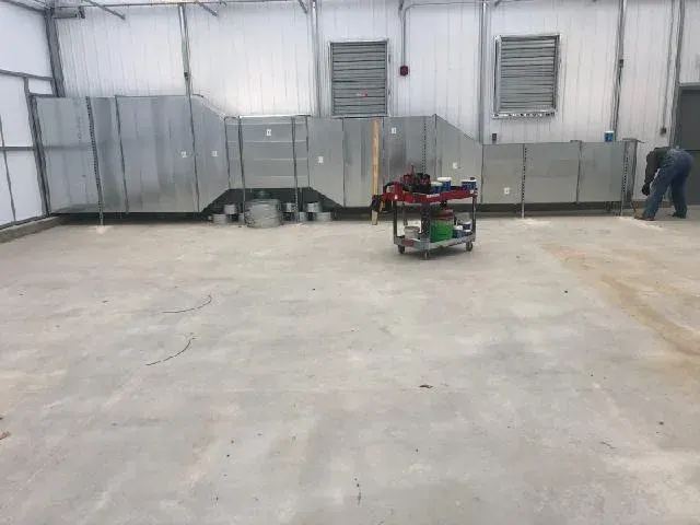 Fabricated sheet-metal duct run installed along the wall of a large commercial space