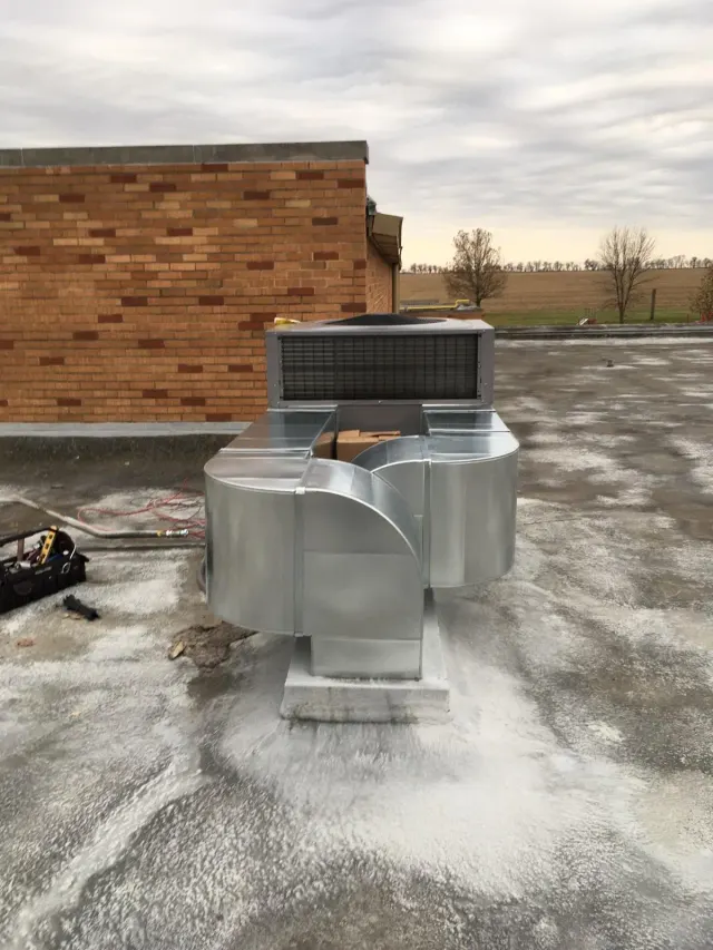 Custom sheet-metal duct transition feeding a rooftop package unit