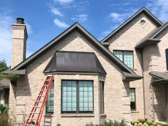Custom architectural metal bay-window bonnet, hand-formed and installed on site