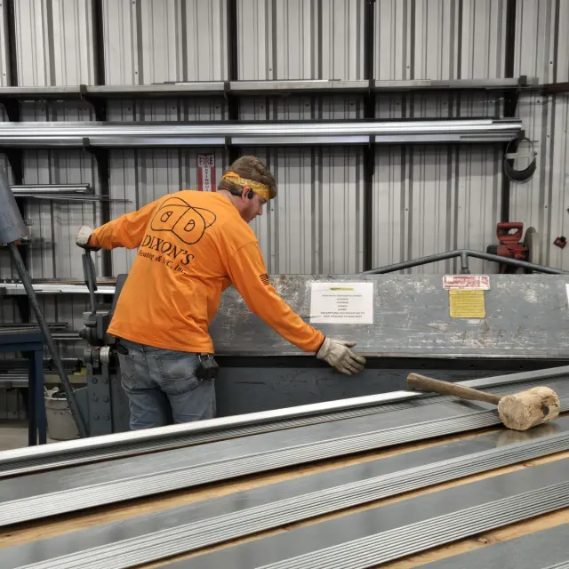 Dixon's technician pulling long lengths of galvanized stock from the shop racks