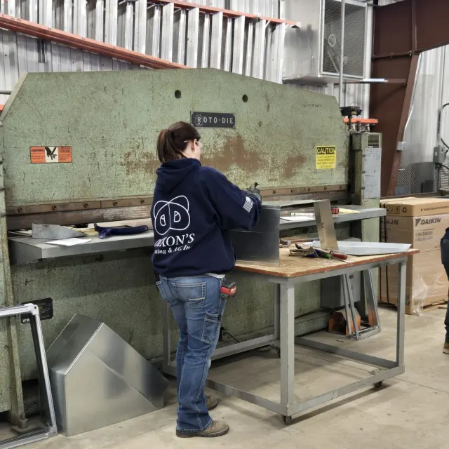 Dixon's technician in a navy hoodie forming a duct at the Roto-Die brake