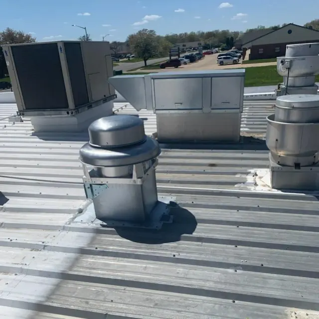 Rooftop ventilation cap set on standing-seam metal roof